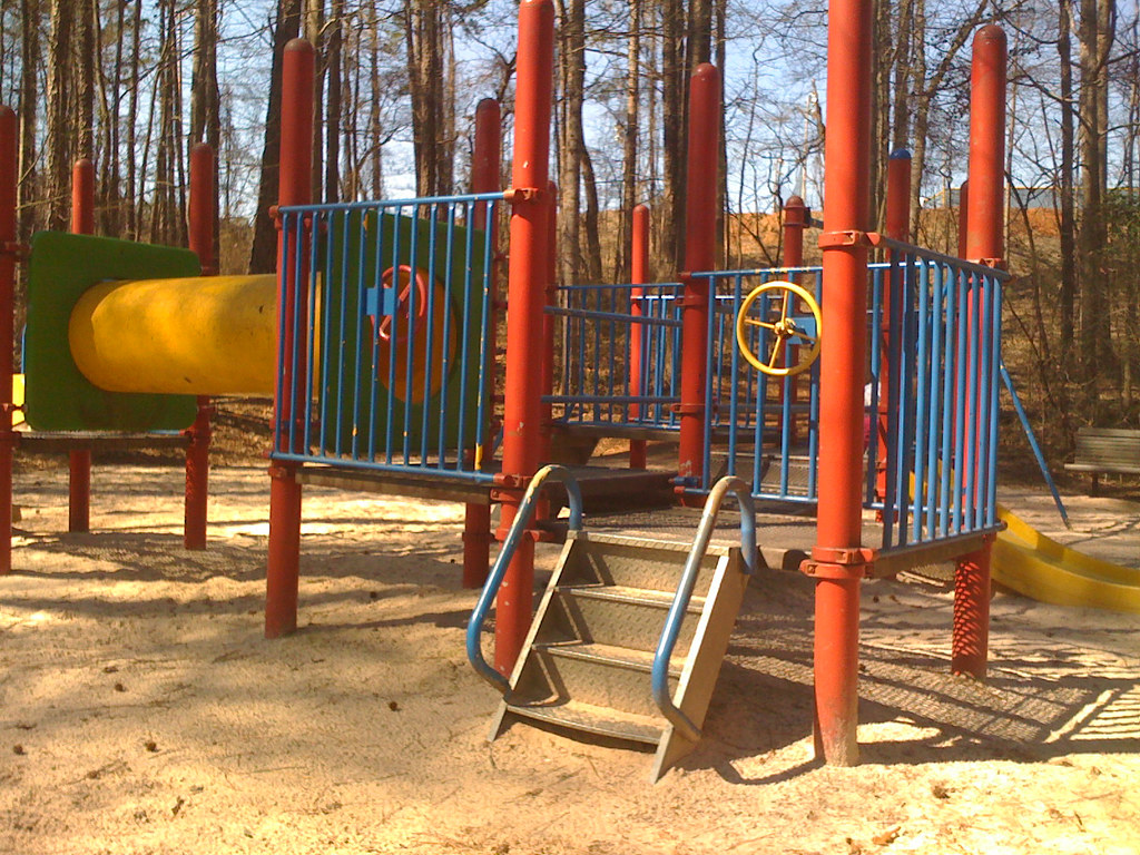 Plac zabaw w parku wśród drzew w Gdańsku