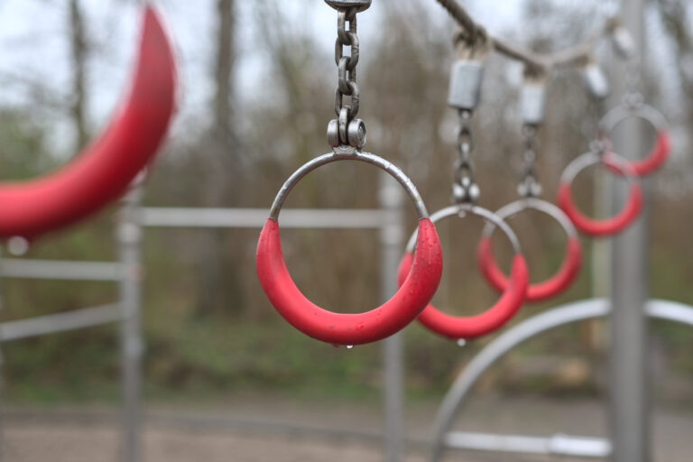 Czerwone koła i uchwyty do zabawy ruchowej na sensorycznym placu zabaw
