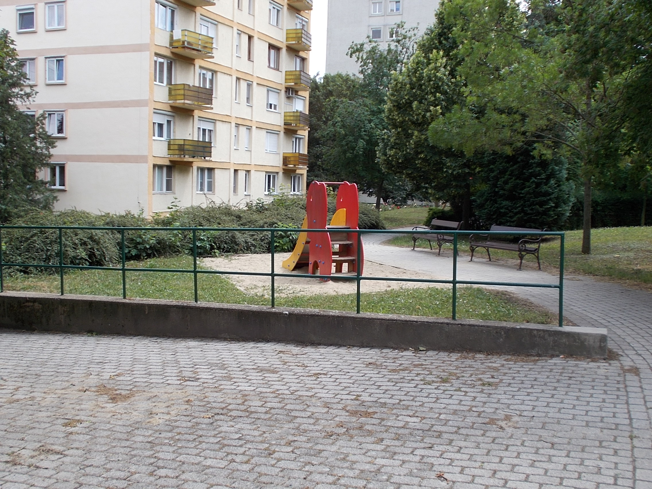 Mała plastikowa zjeżdżalnia dla dzieci w ogrodowej piaskownicy